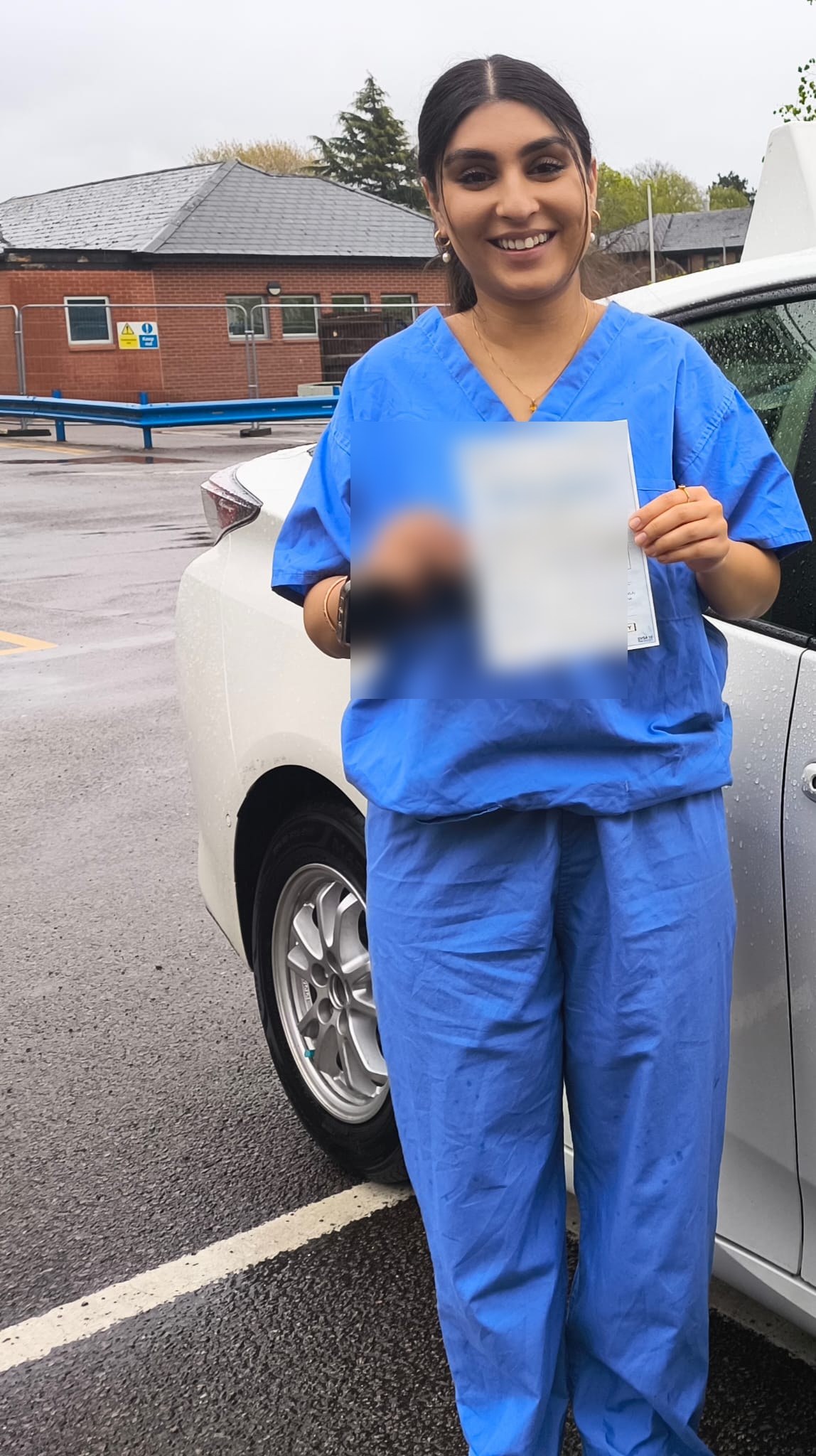 Learner holding her driving test pass certificate